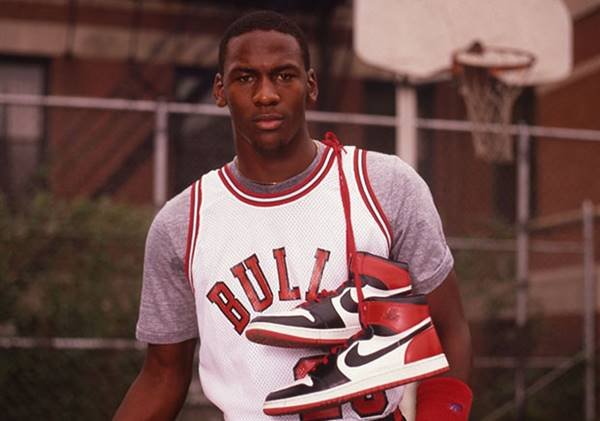 Michael Jordan posando com o primeiro modelo do Nike Air Jordan, nos anos 1980