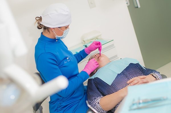 Técnica em odontologia atendendo paciente