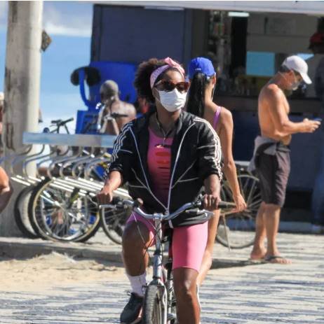Adriana Bombom na praia de bicicleta