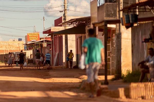 Pessoas caminham em rua de terra no DF - Metrópoles