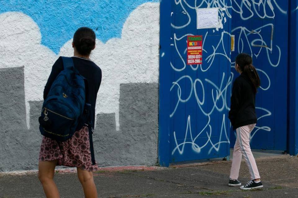Aluno em frente de escola fechada