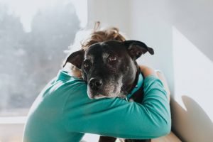 Criança abraçando cachorro