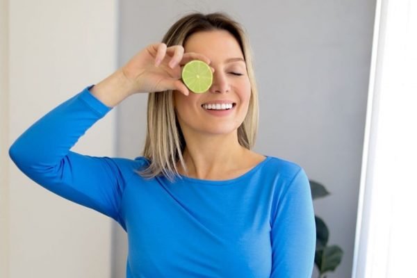 Samanta Piacini, fundadora da marca Lemon Basics, segurando uma rodela de limão em frente ao olho