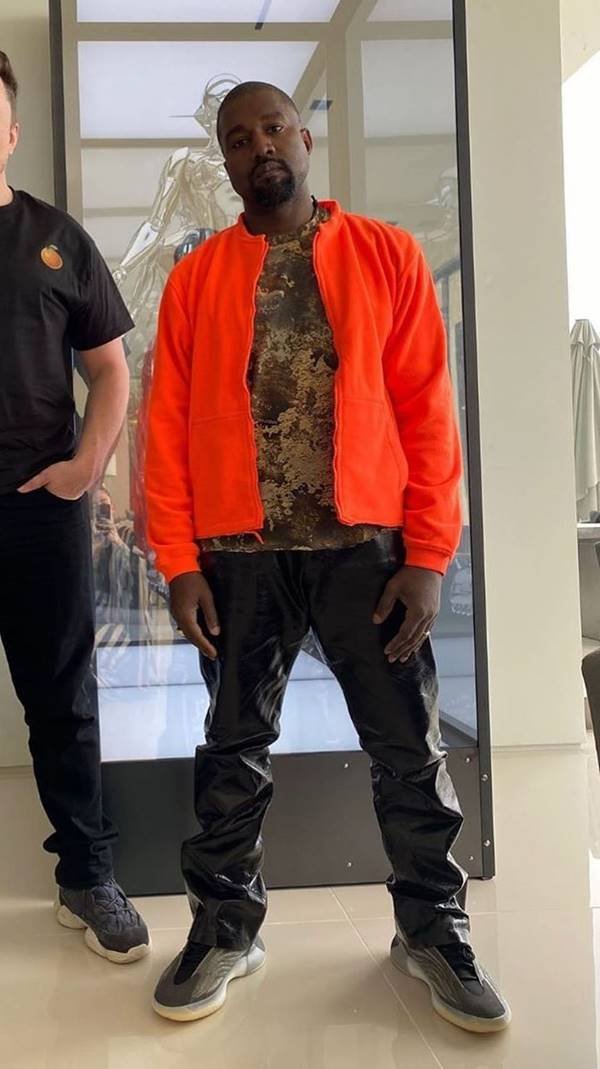 Kanye West com casaco laranja vibrante