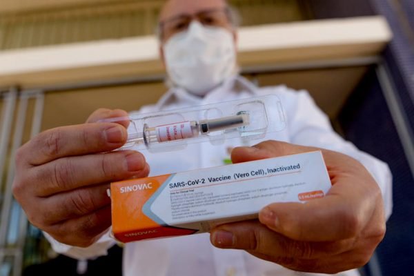 Doutor Gustavo Romero, coordenador do estudo da vacina contra Covid-19 no Distrito Federal, mostra embalagem e seringa utilizada para a imunização - vacina covid
