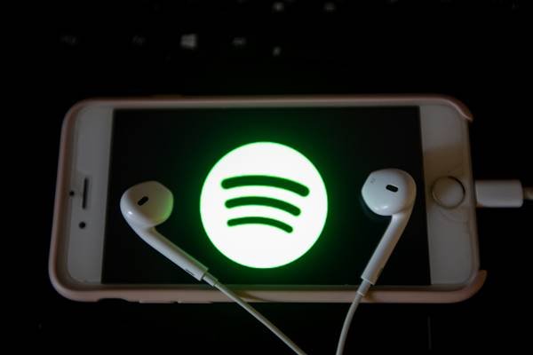Celular com logomarca do Spotify e fones de ouvido