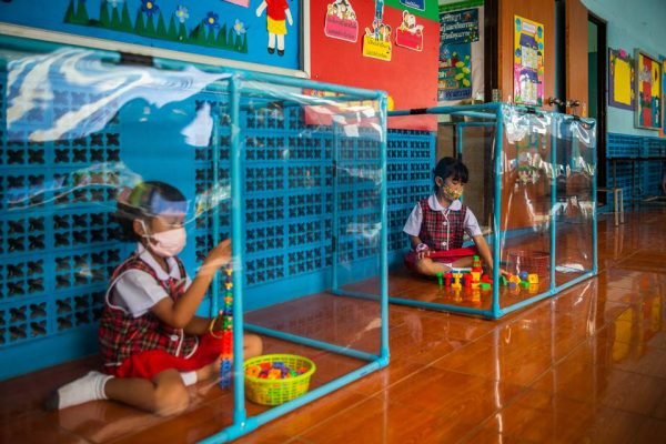 Cubos isolados de crianças em escola na Tailandia. Volta às aulas na pandemia.