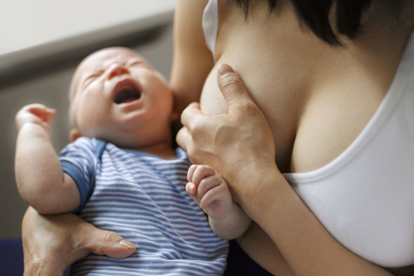 Bebê chorando enquanto mama