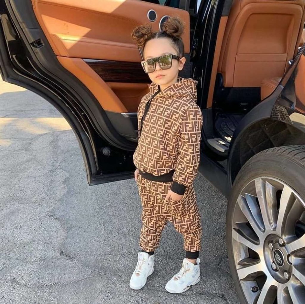 menina ao lado de um carro