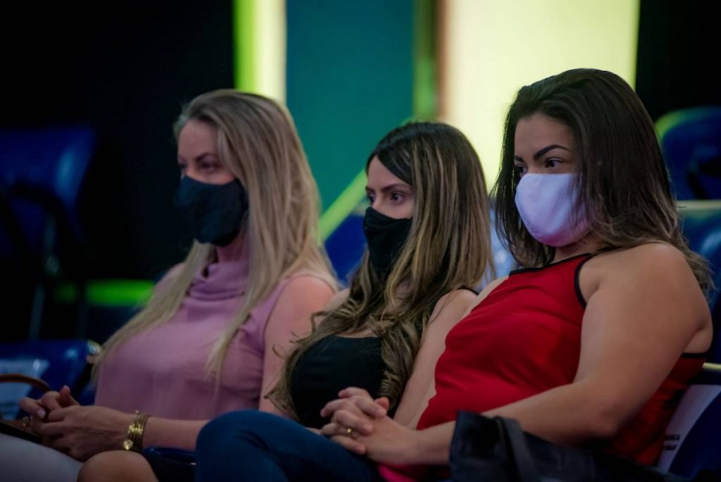 mulheres de máscara olhando para frente