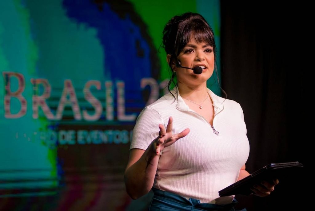 mulher com microfone falando ao público