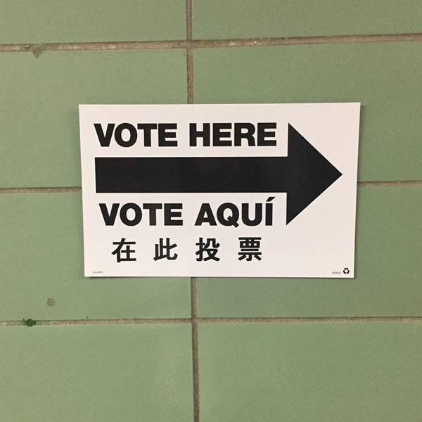 Placa com a expressão "Vote aqui" em inglês