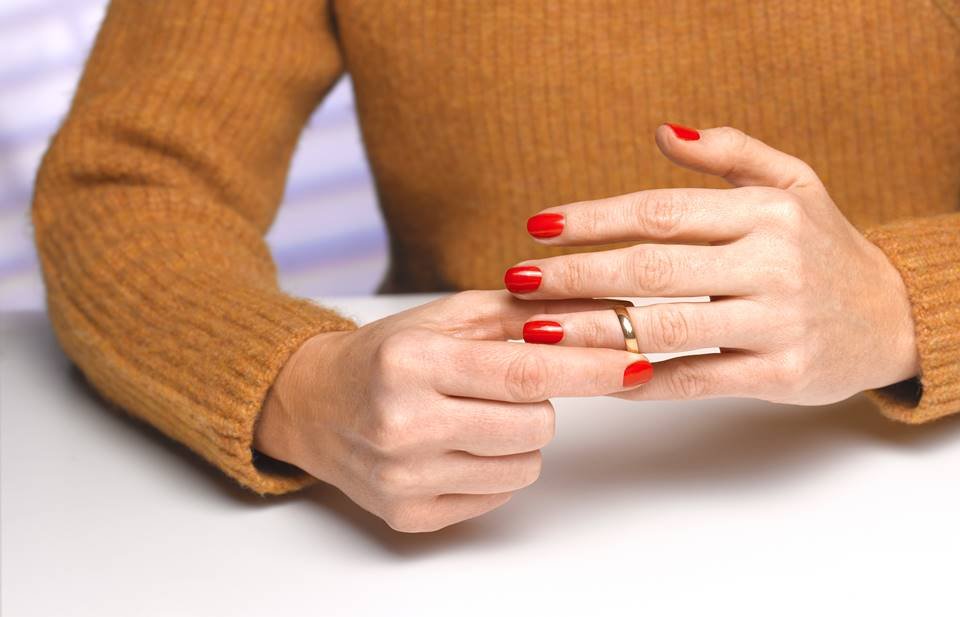 Mulher tirando uma aliança dourada do dedo anelar esquerdo - metropoles - traição