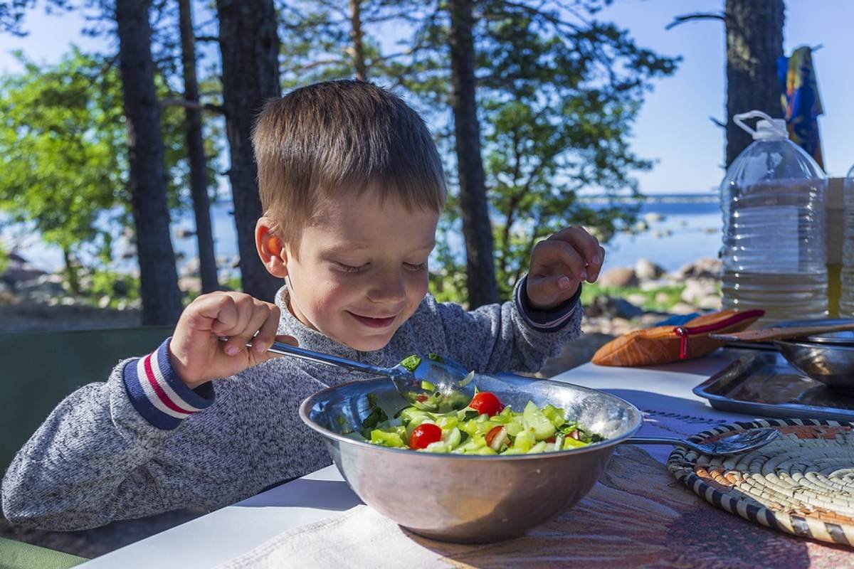 Criança comendo salada