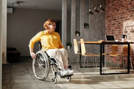 Mulher com blusa amarela em cadeira de rodas