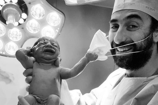 Bebê tirando a máscara de médico