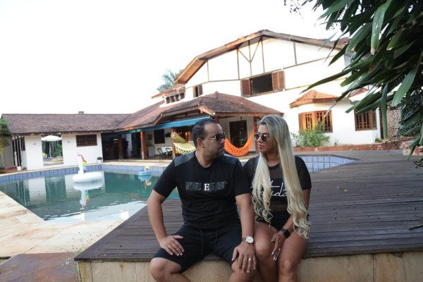 casal em frente a mansão