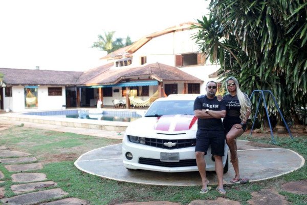 casal em frente a mansão e camaro
