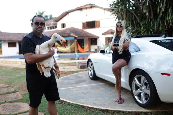 casal em frente a mansão segurando ganso