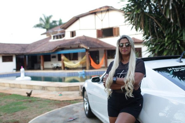 mulher encostada em camaro