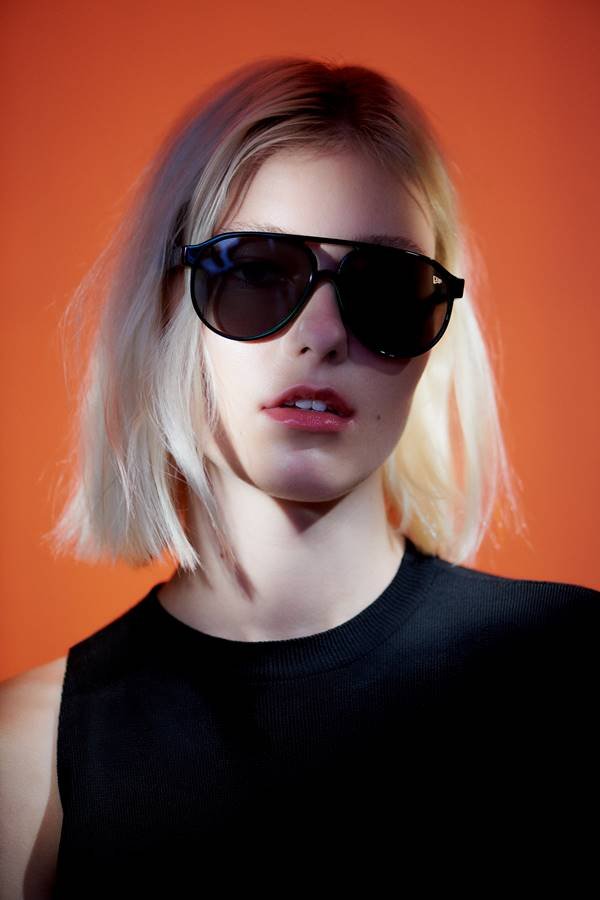 Modelo em campanha usando óculos de sol, da coleção da New Era com a Evoke