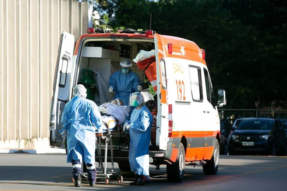 Paciente em maca e profissionais de saúde