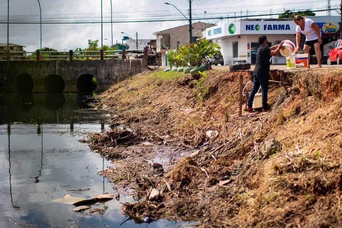 Moradores do bairro Perpétuo Socorro, Zona Central do Amapá, coletam água de tubulação às margens do esgoto.