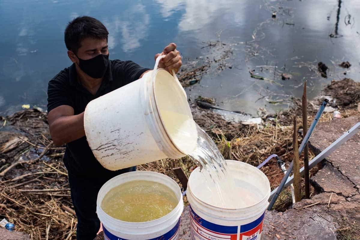 Moradores do bairro Perpétuo Socorro, Zona Central do Amapá, coletam água de tubulação às margens do esgoto.