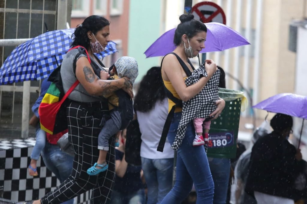 Pessoas aglomeradas se protegem da chuva na região central de São Paulo