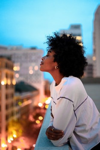 mulher negra na varanda de um prédio