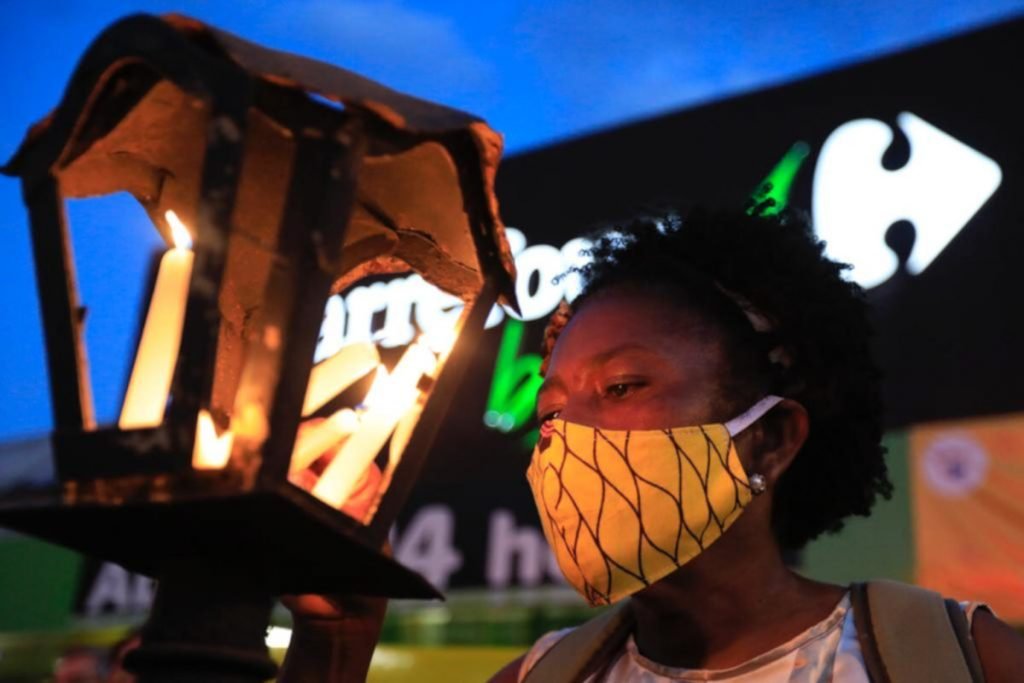 mulher negra com vela em frente ao Carrefour