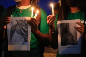 pessoas mostram fotos de homens negros mortos
