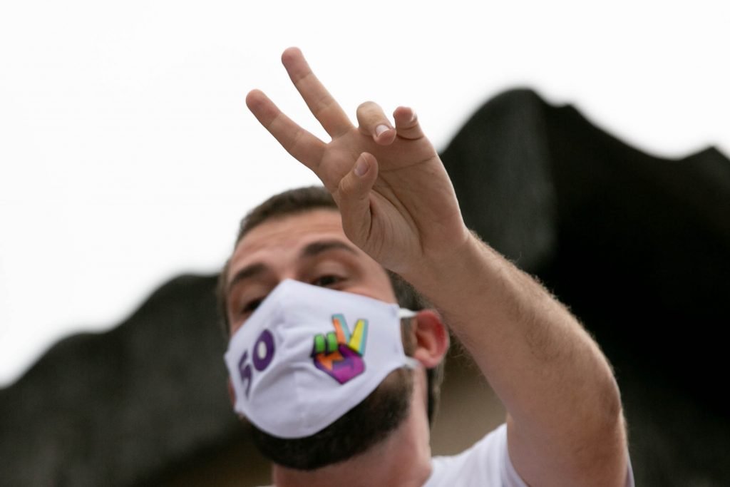 Guilherme Boulos cumprimenta apoiadores da varanda de sua residência