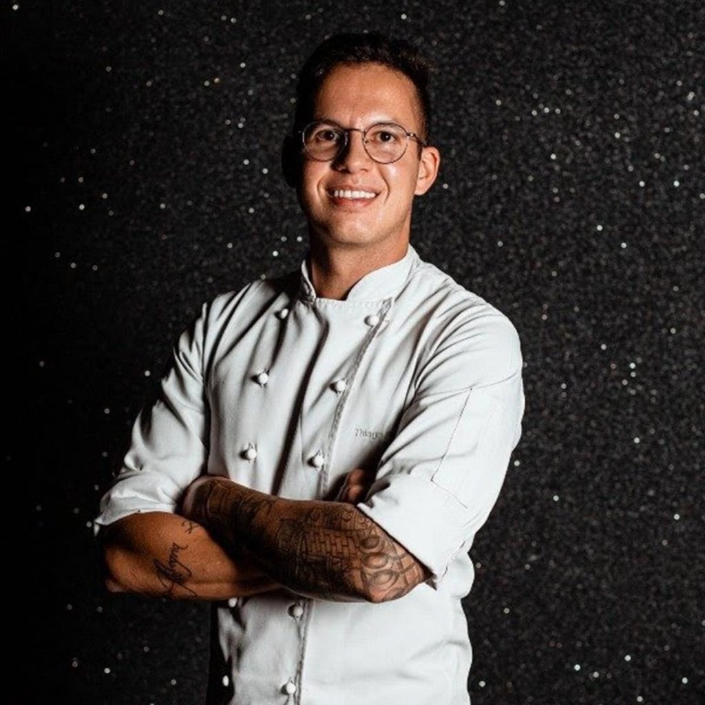 Chef Thiago Paraiso, homem ao centro da foto de dolmã