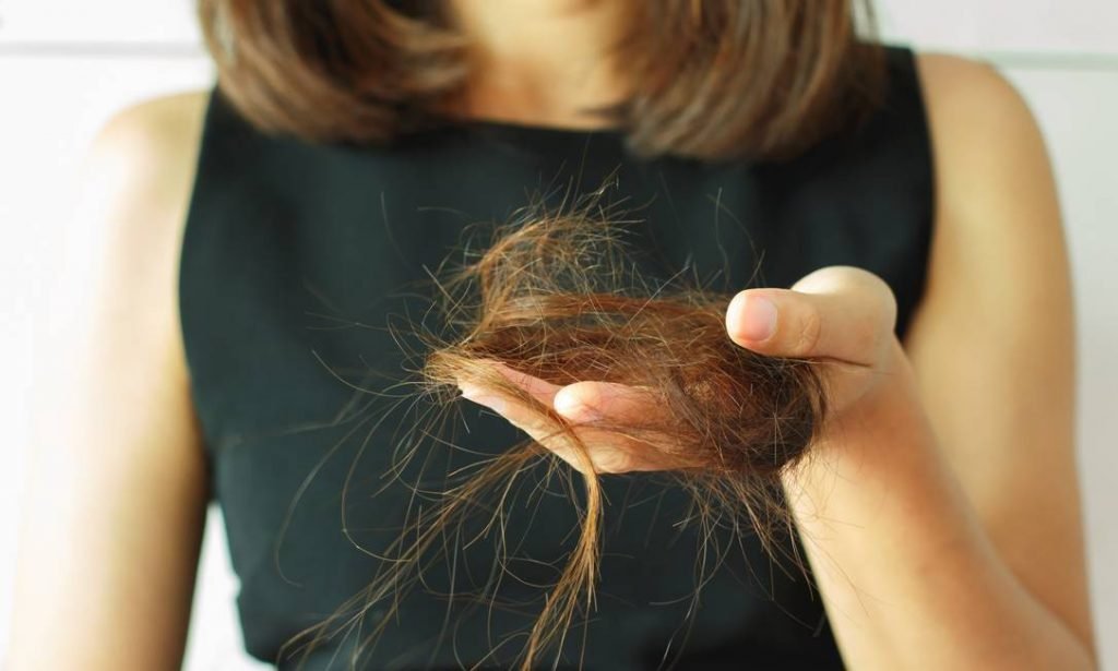 mulher segurando tufos de cabelo