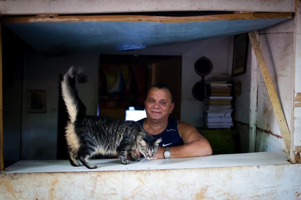 Homem na janela com gato