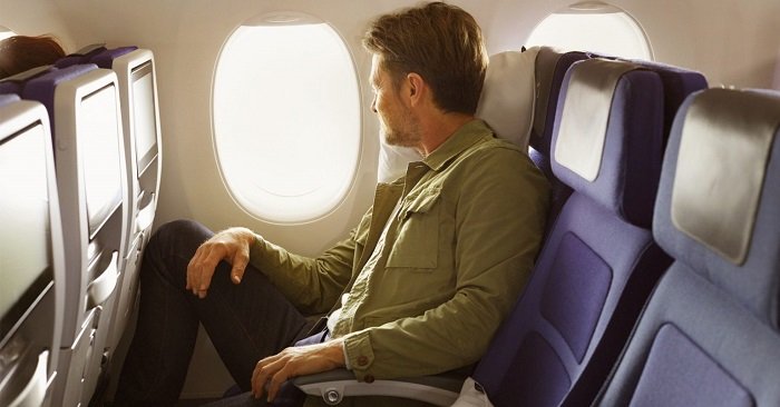 homem sentado em cadeira de avião