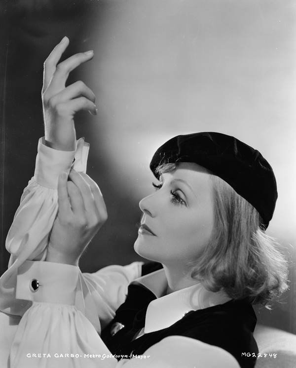 Greta Garbo usando boina preta, camisa branca e colete