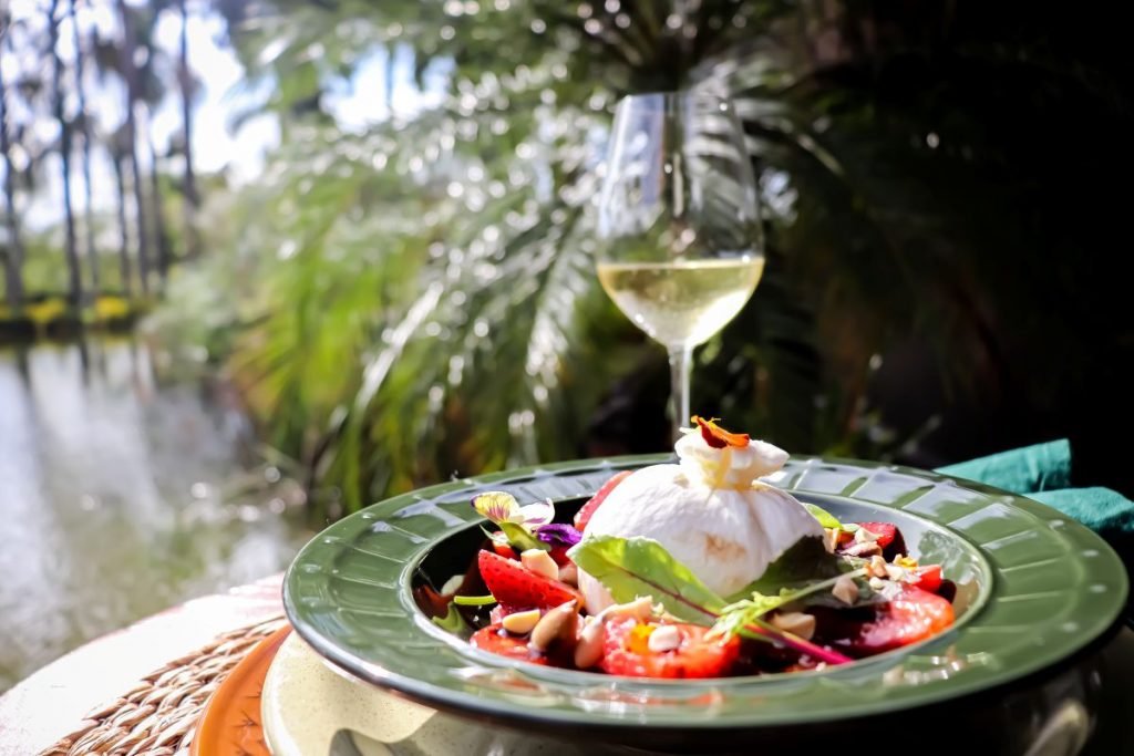 Burrata servida com salada de morangos, aceto balsâmico e uma camada de jamón ibérico