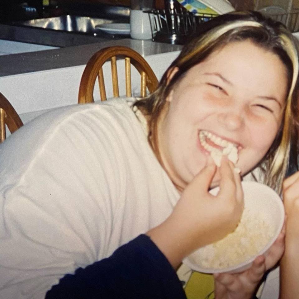Foto de uma mulher loira, gorda, comendo pipoca e usando uma camisa branca - Metrópoles