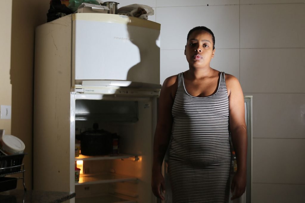 Karen Cristina mostra a geladeira quase vazia