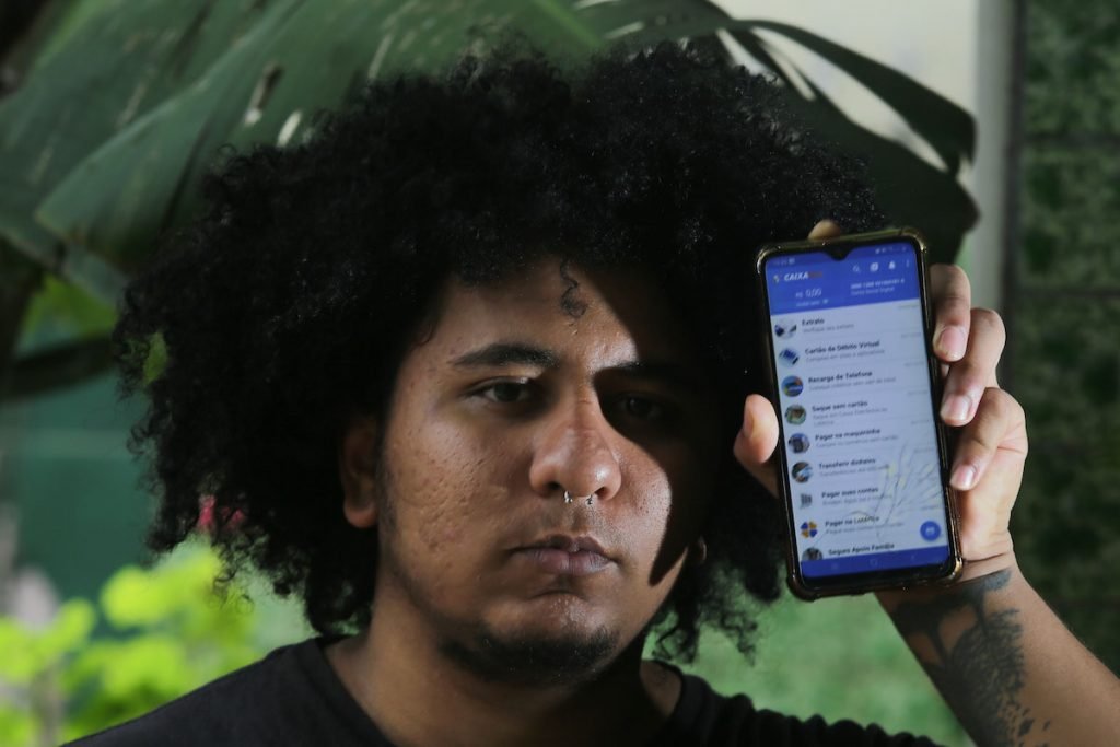 Ailton Rodrigues, morador de São Miguel Paulista, mostra app da Caixa