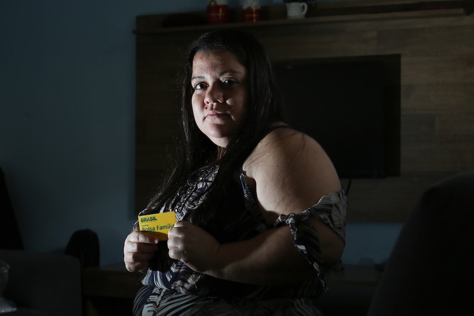 Daiana Rodrigues segura seu cartão do Bolsa Família