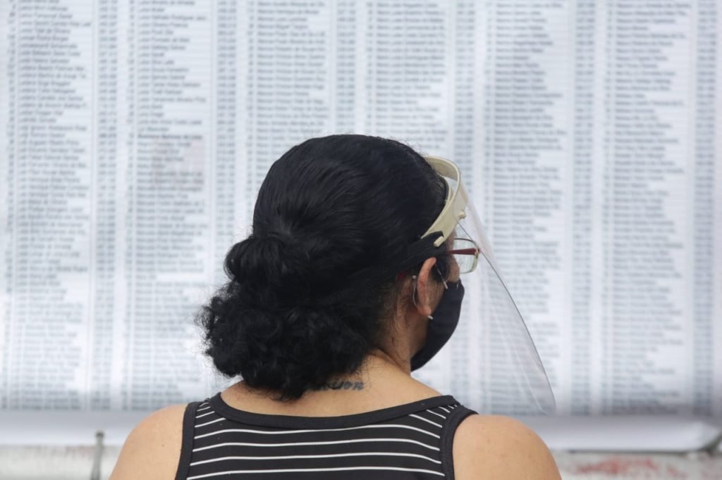 Mulher aparece em frente a uma lista com nome de alunos inscritos na Fuvest