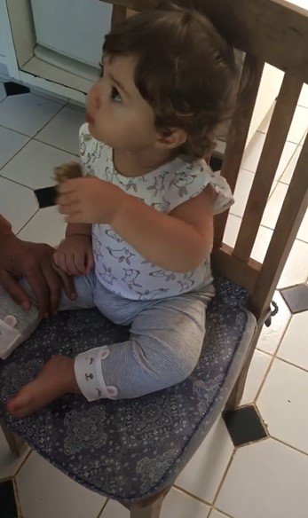 Clara Maria comendo barrinha de cereais
