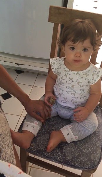 Clara Maria comendo barrinha de cereais