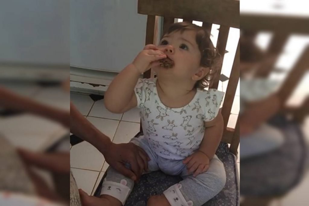Clara Maria comendo barrinha de cereais