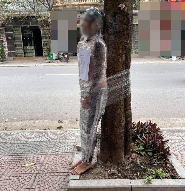 Homem amarrado em árvore