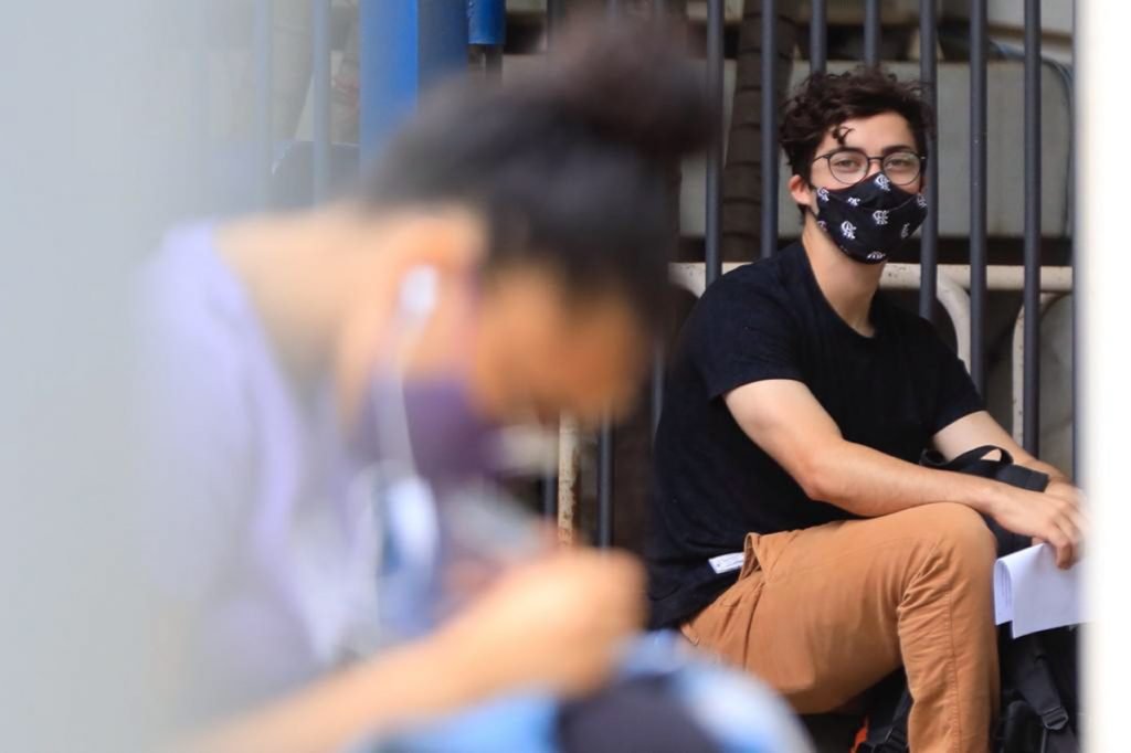 Fotografia colorida de dois jovens antes da entrada para realização do Enem em 2021 Provas do Enem 2021