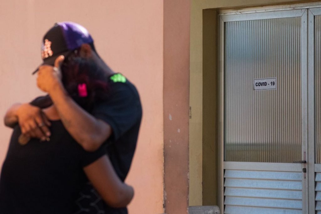 Casal se emociona em frente a uma unidade de saúde que atende casos de Covid-19